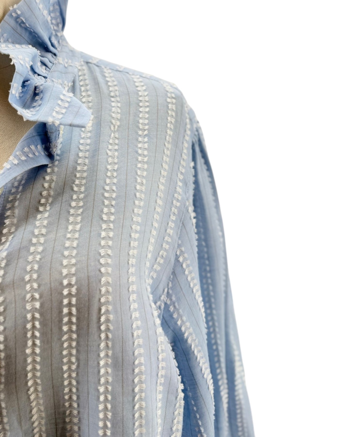 Close-up of a blue and white striped fabric with intricate patterns.