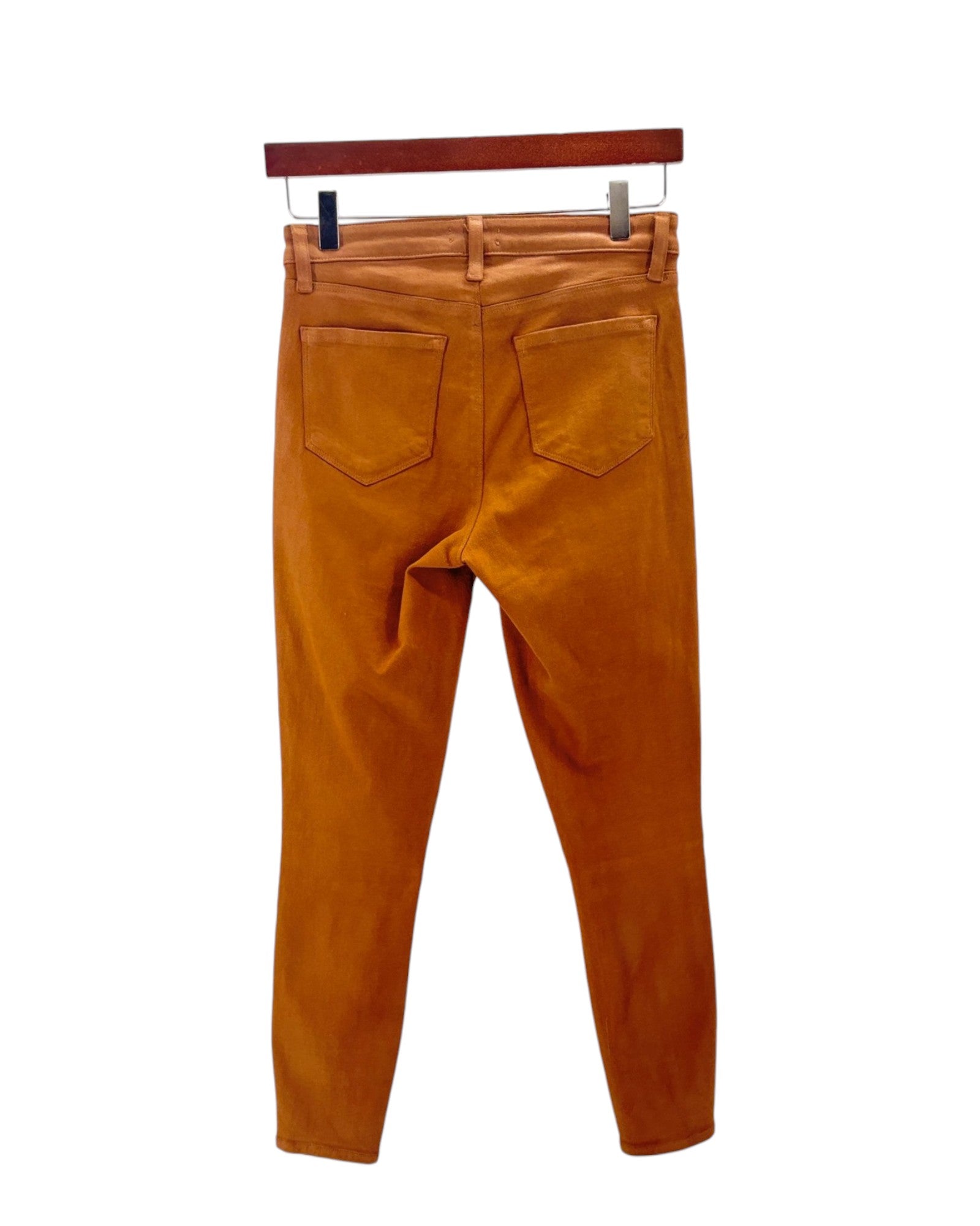 Orange pants on a hanger against a white background