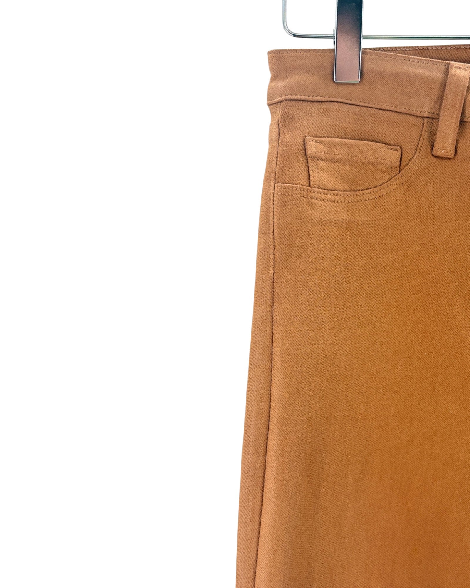 Brown pants on a hanger against a white background