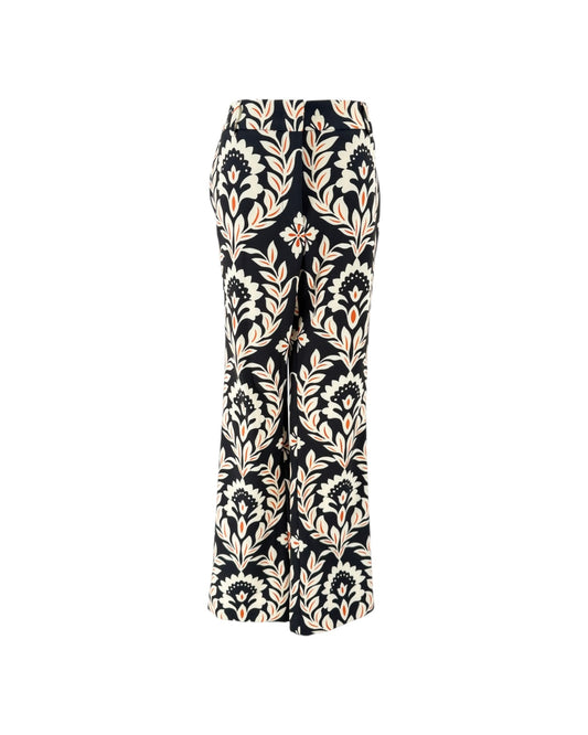 A pair of wide-leg trousers featuring a black base with a beige and cream botanical damask pattern, shown against a plain white background.