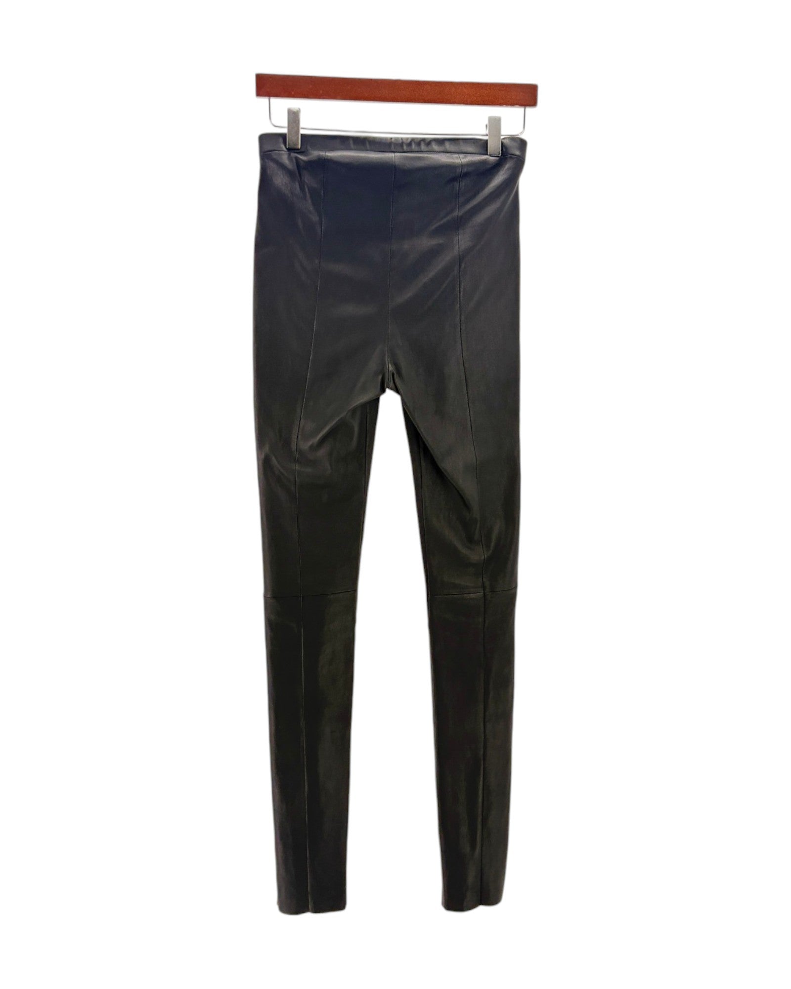 Black leather pants on a hanger against a white background