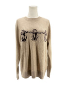 Beige sweater with black graphic design on a mannequin against a white background