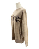 Beige sweater with black design on a mannequin against a white background