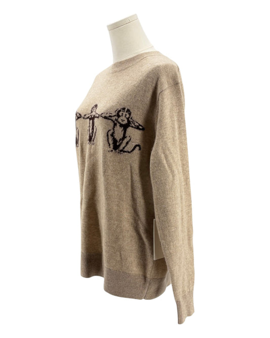 Beige sweater with black design on a mannequin against a white background