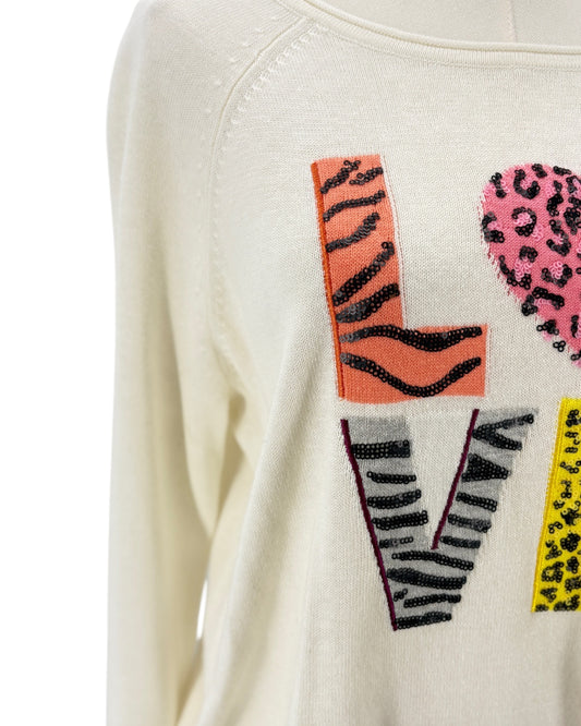 Close-up of a white sweater with colorful patterned text on a white background