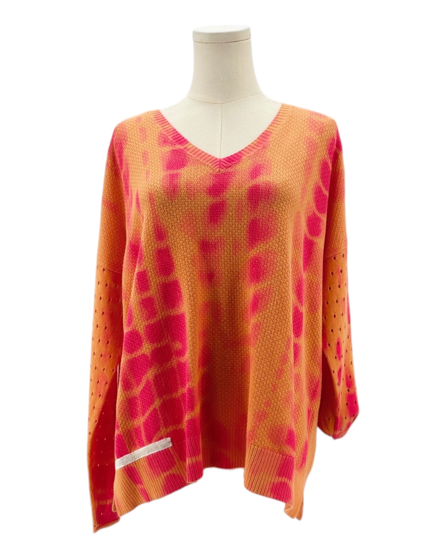 Orange and pink patterned sweater on a mannequin against a white background