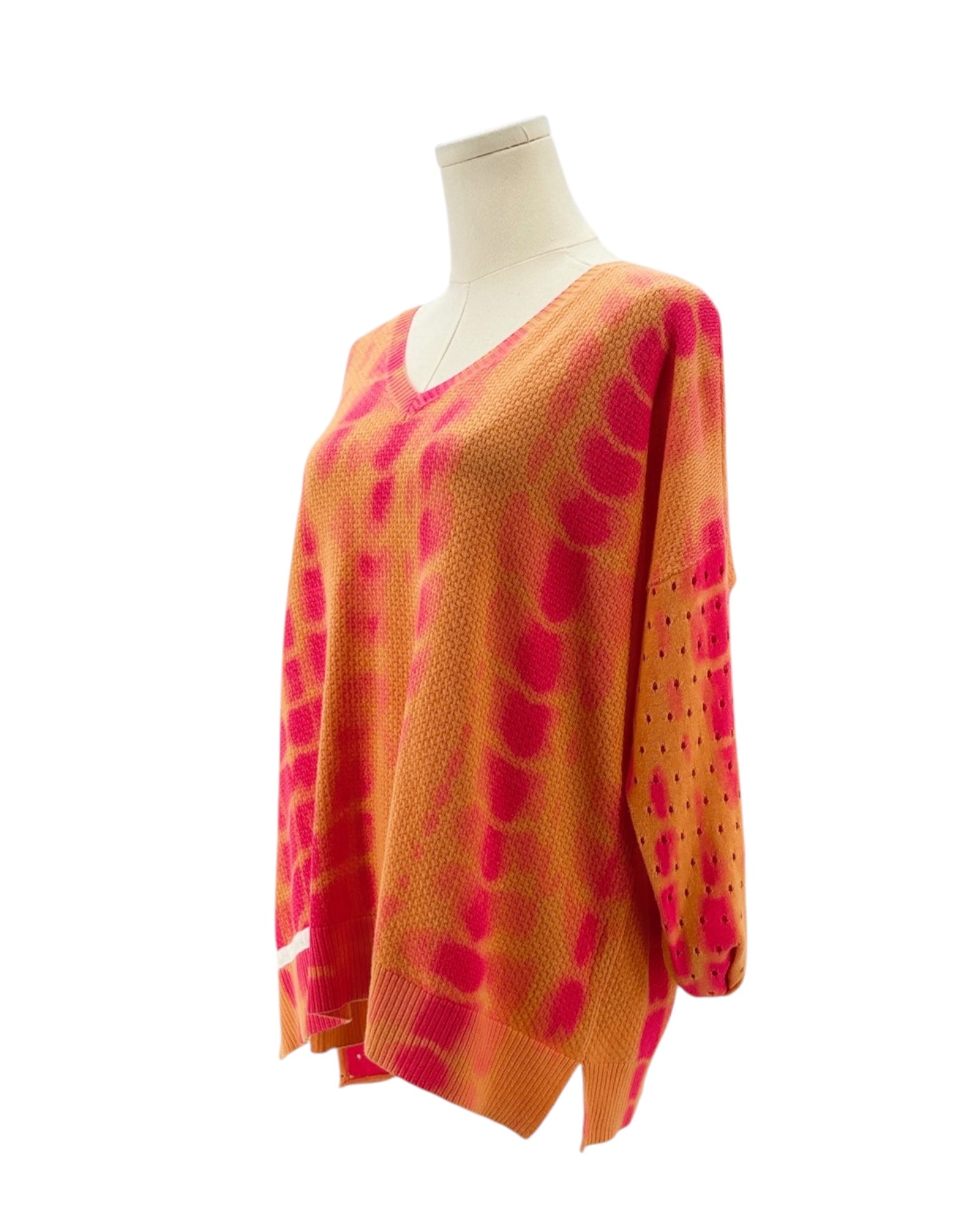 Orange and pink patterned sweater on a mannequin against a white background