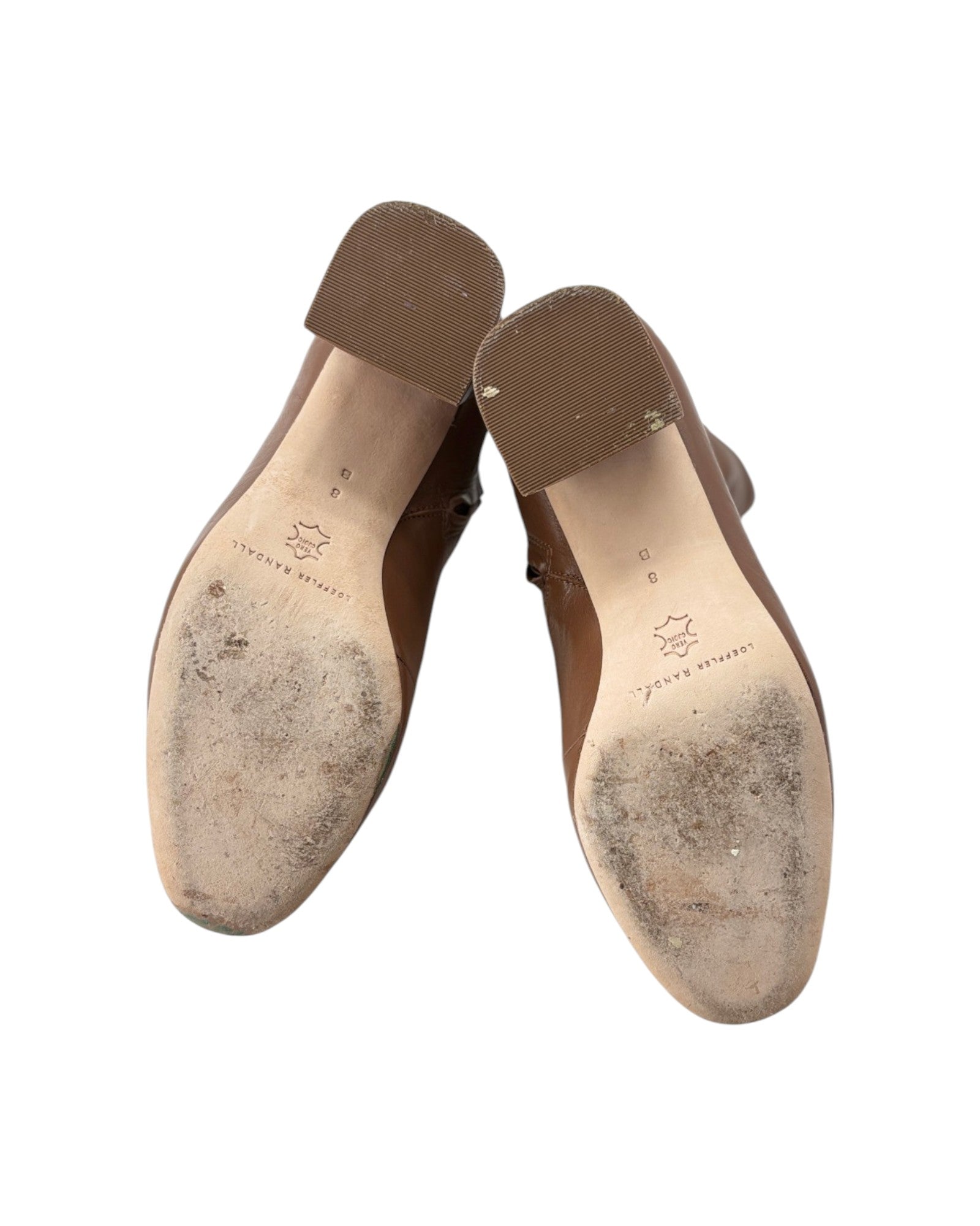 Brown leather shoes with soles showing wear on a white background