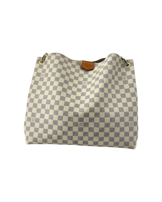 Checkered handbag with brown leather zipper on a white background