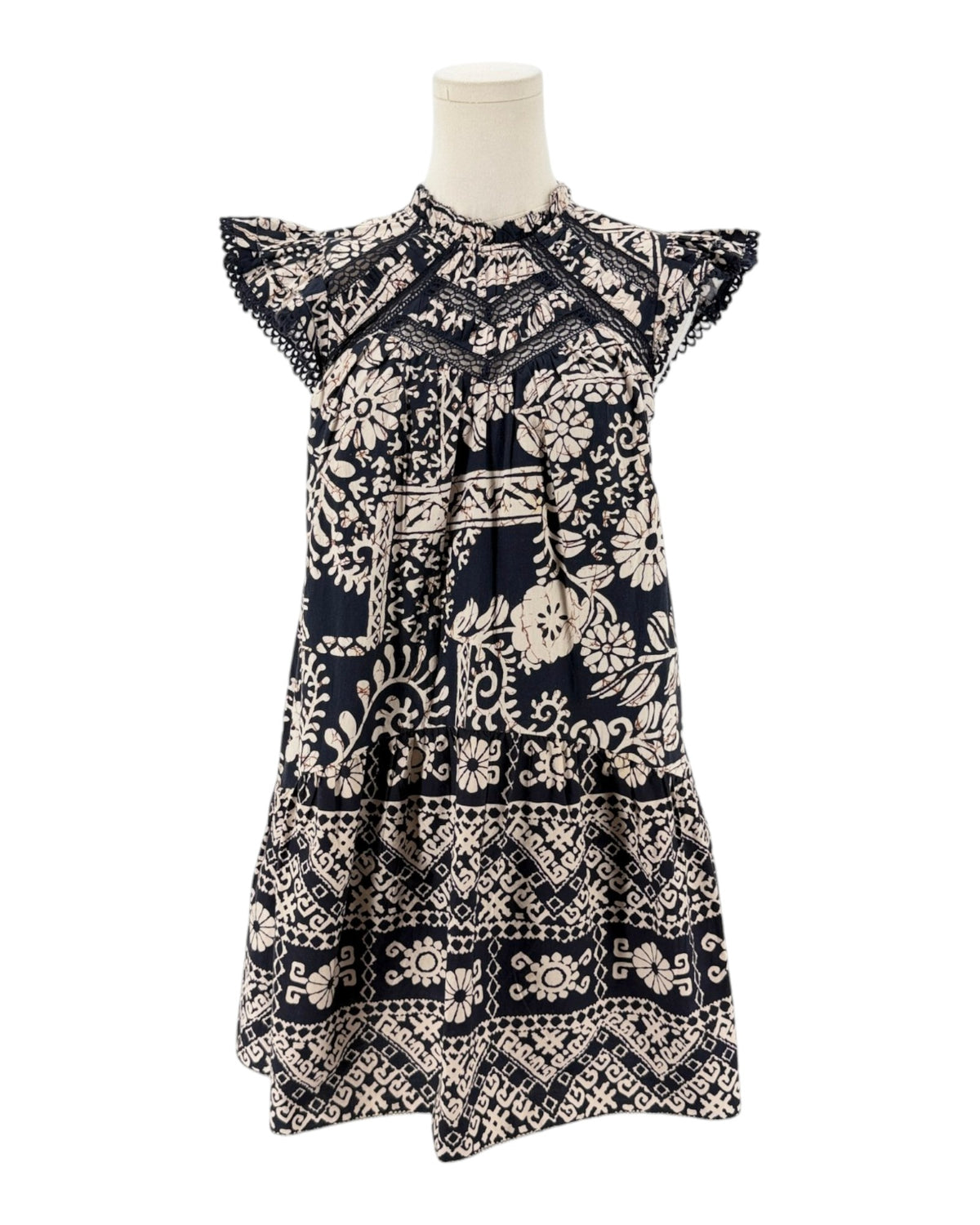 A short-sleeve tiered dress with a navy blue and cream block-print floral pattern, displayed on a mannequin torso against a white background.