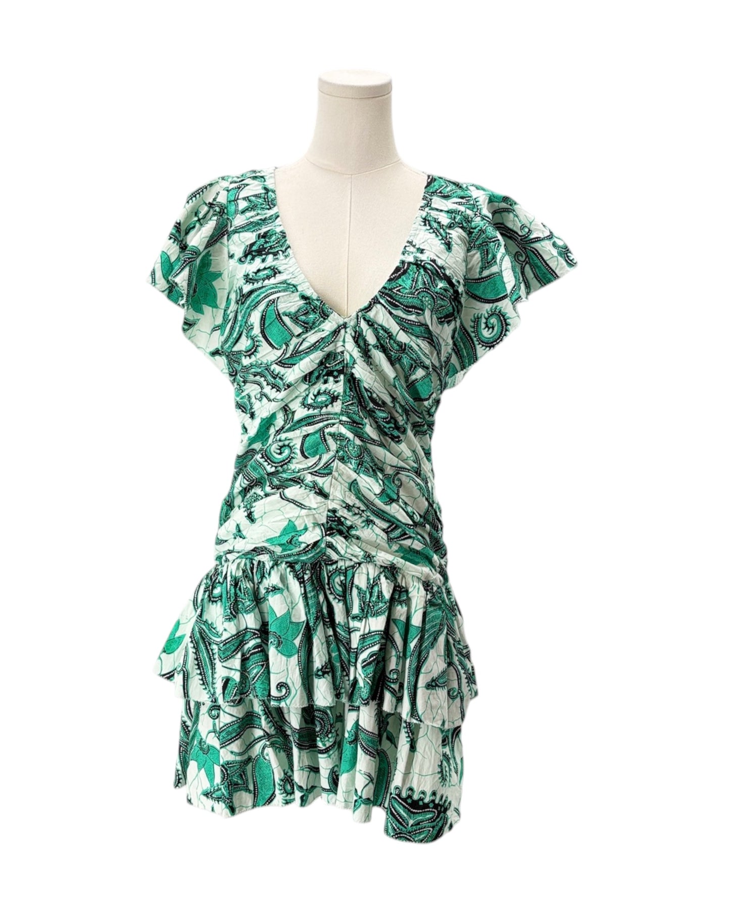 Green and white patterned dress on a mannequin against a white background