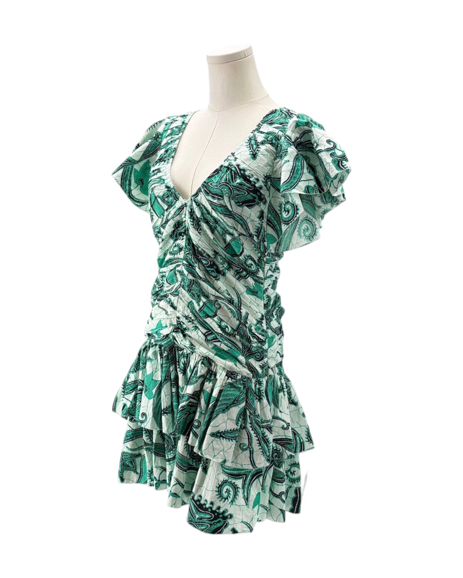 Green and white patterned dress on a mannequin against a white background