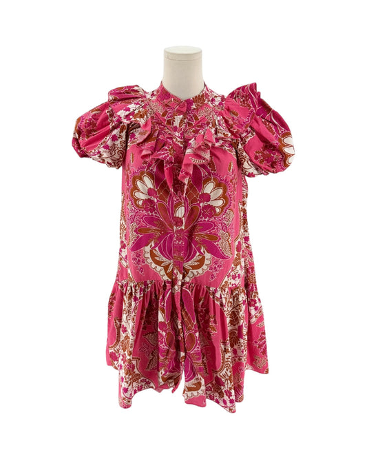 A pink patterned short-sleeve blouse displayed on a mannequin torso against a plain white background. The blouse features a bold floral and paisley print in pink, white, and brown, with ruffled details at the collar and sleeves.