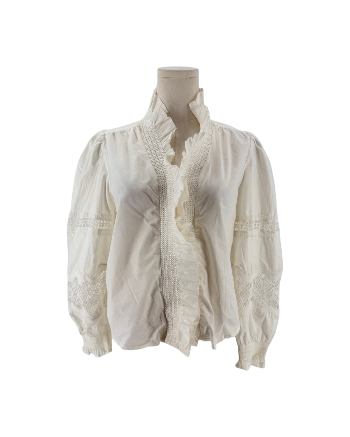 White long sleeve blouse with a ruffle collar and eyelet detailing on the sleeves on a mannequin on a white background