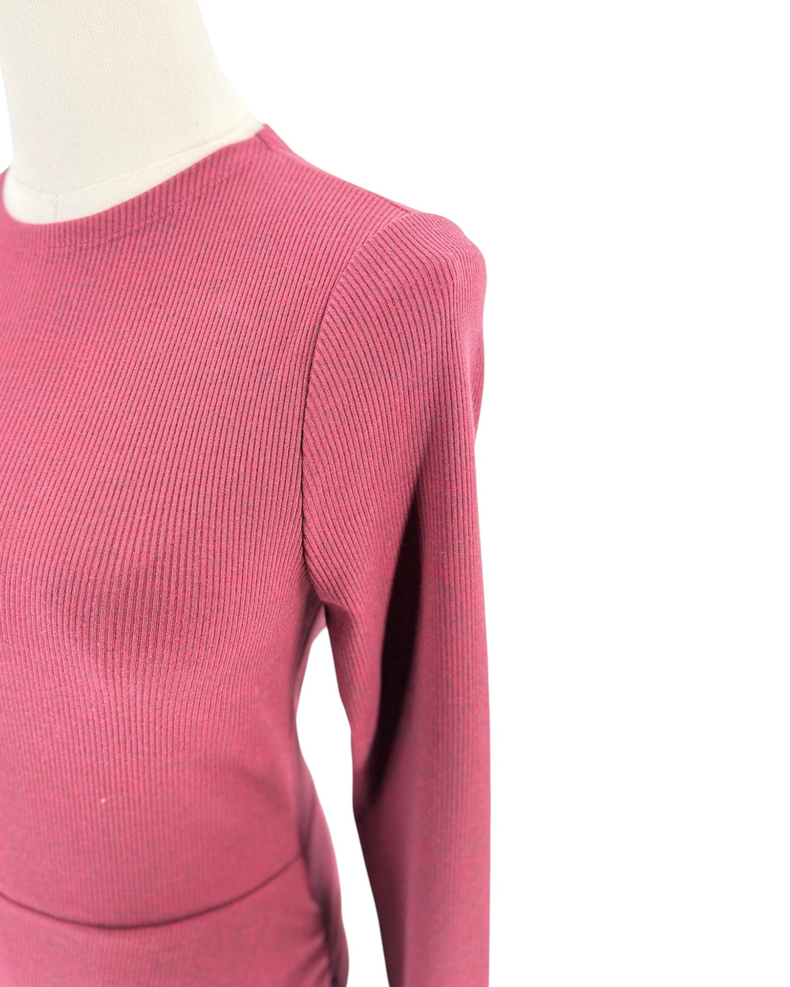 A close-up of a ribbed knit long-sleeve top in a dusty rose pink color, displayed on a mannequin against a plain white background.
