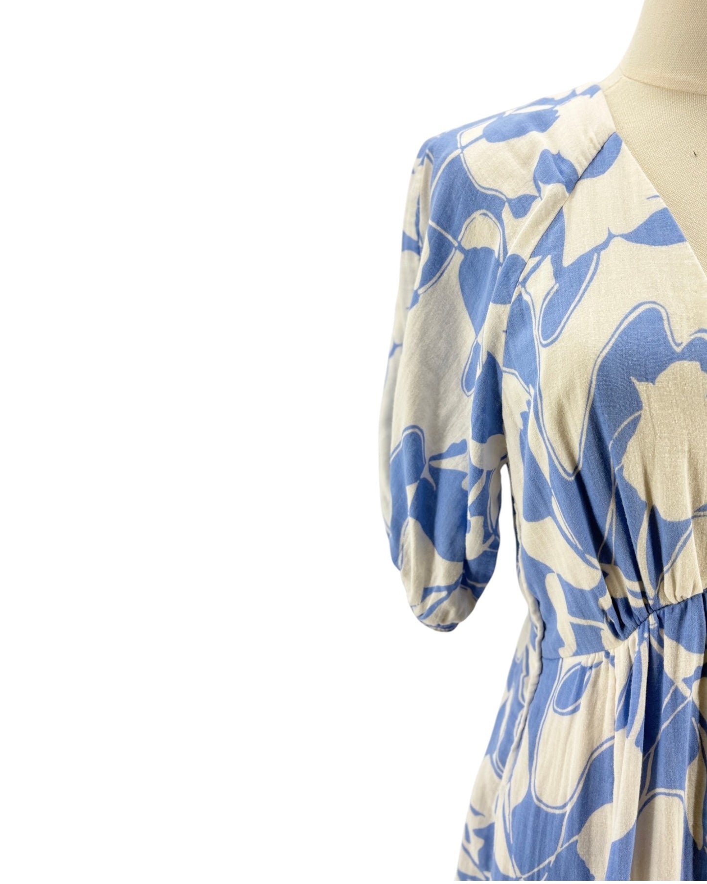 Blue and white floral dress on a mannequin against a white background