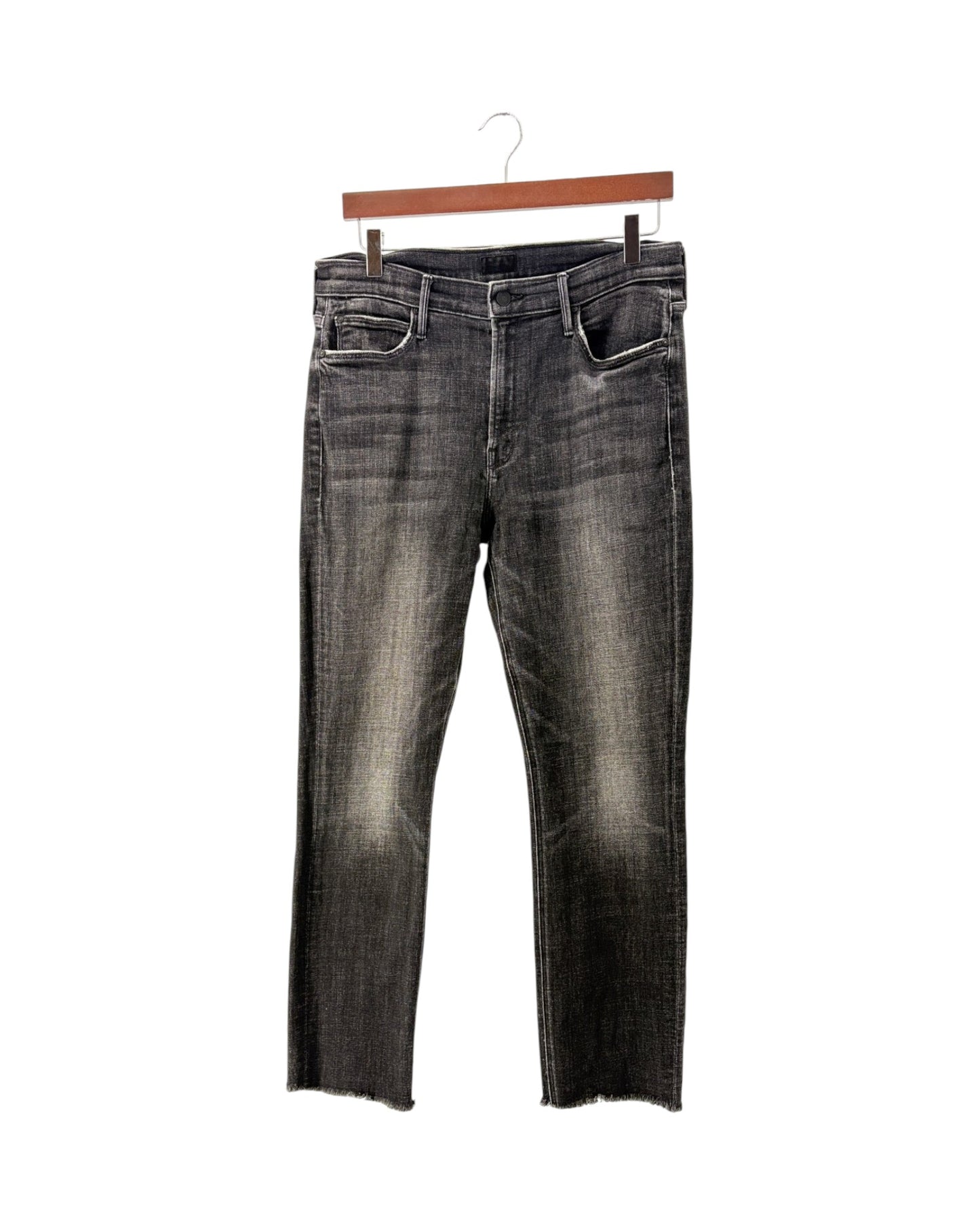 A pair of dark gray washed denim jeans with a faded, distressed finish and raw hems, hanging from a wooden hanger against a plain white background.