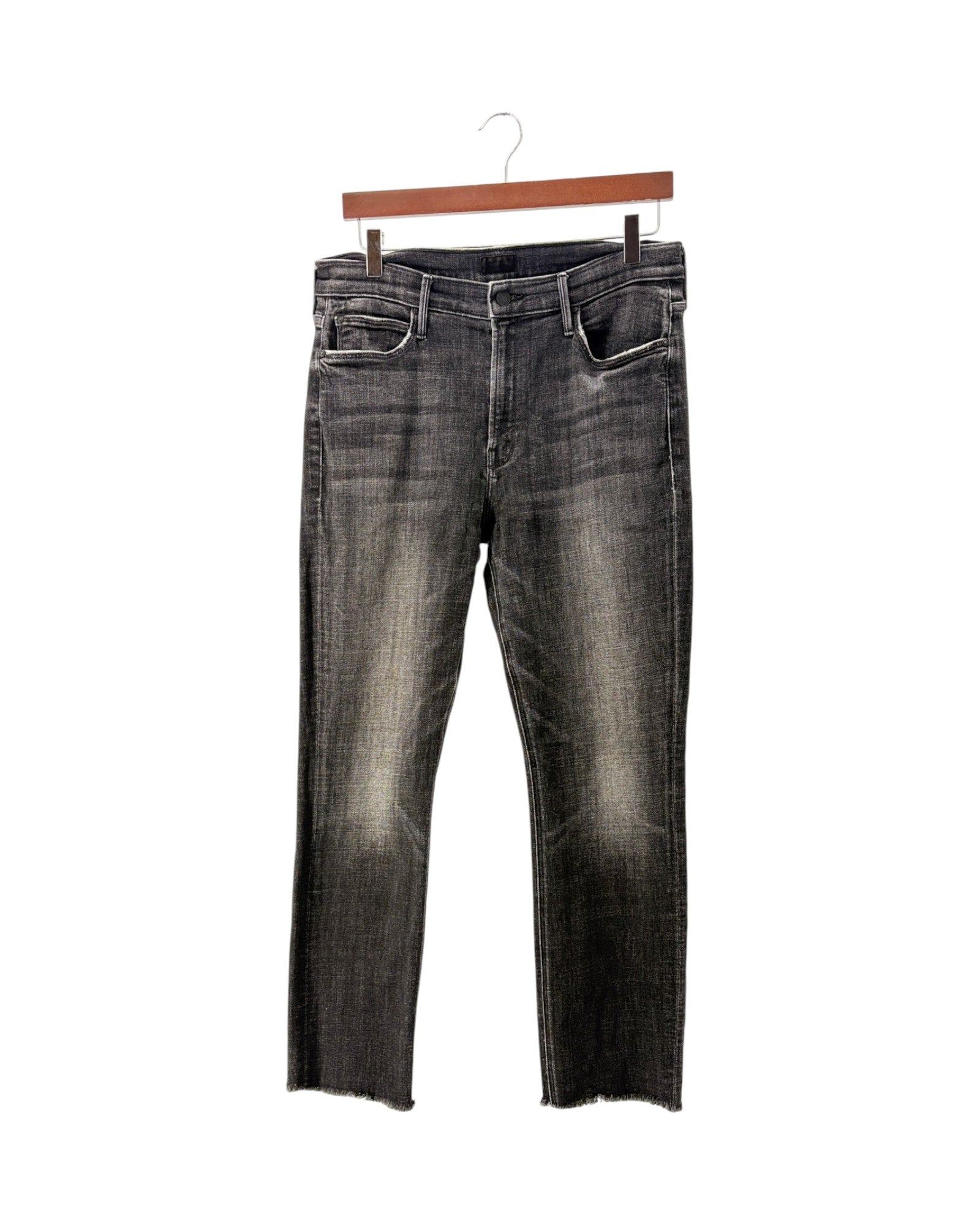 A pair of dark gray washed denim jeans with a faded, distressed finish and raw hems, hanging from a wooden hanger against a plain white background.