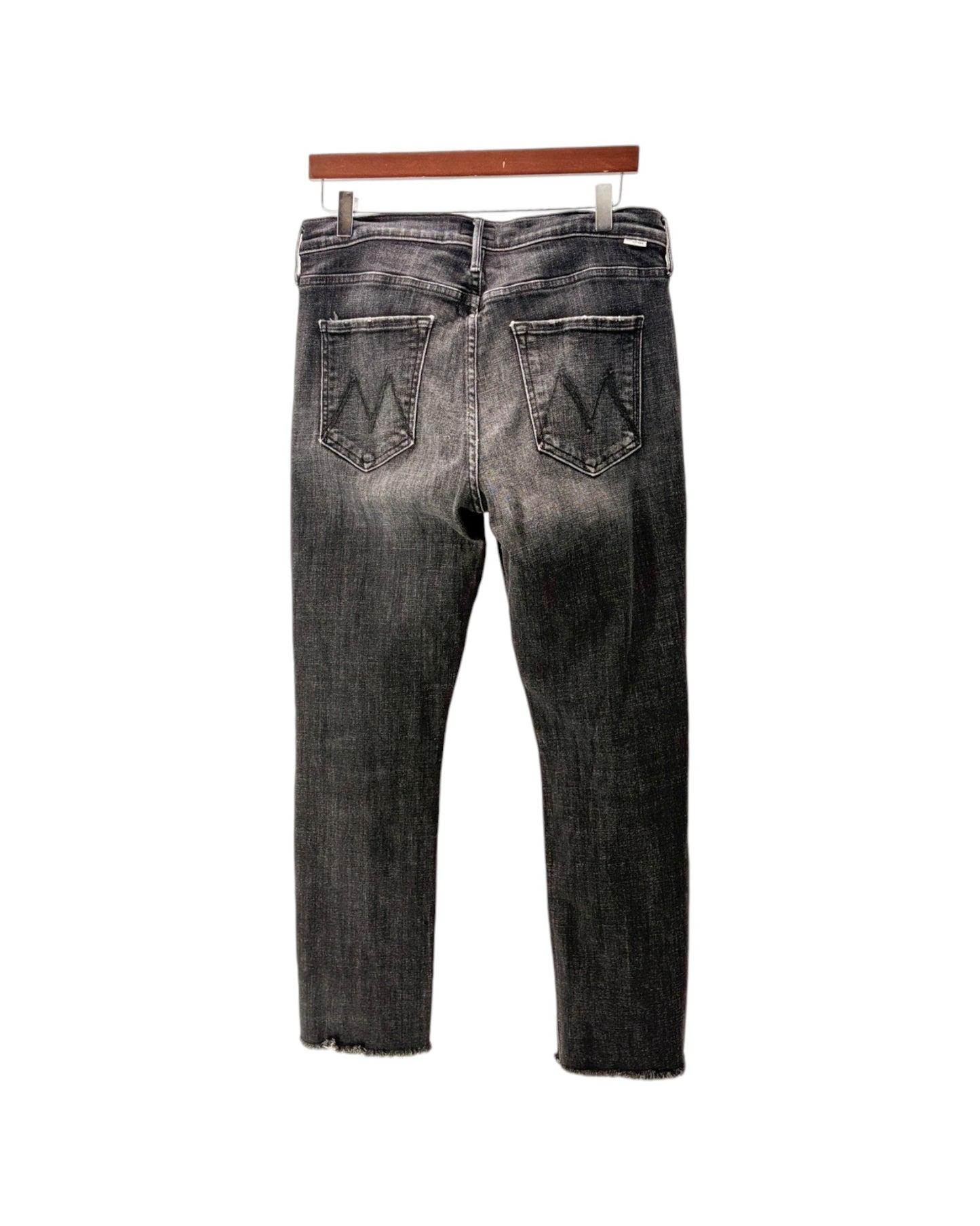 Back view of a pair of dark gray washed denim jeans hanging on a wooden hanger against a white background.