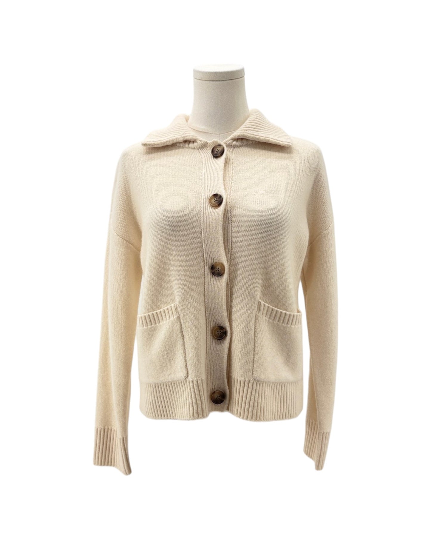 A cream-colored knit cardigan sweater with a collar, brown buttons, and front pockets, displayed on a mannequin torso against a white background.