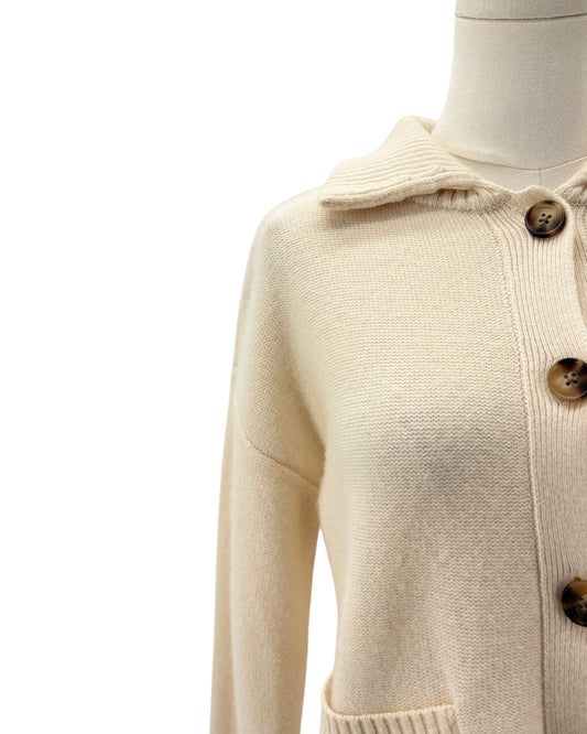 Cream-colored knit cardigan sweater with a collar and brown buttons, displayed on a mannequin torso against a white background.