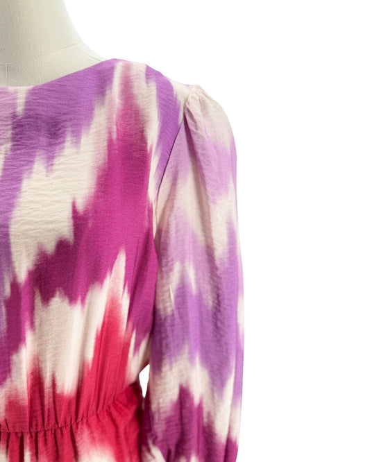 Mannequin wearing a tie-dye dress with pink, purple, and white pattern on a white background