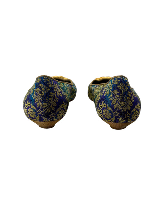 Pair of blue and gold patterned shoes on a white background