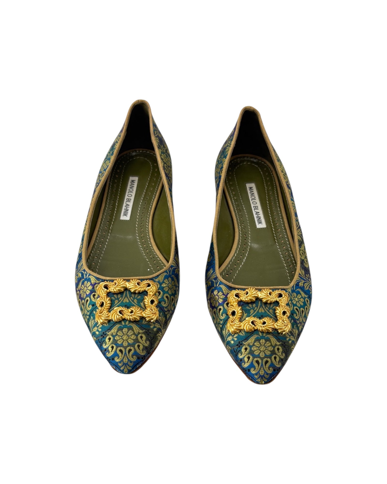 Pair of decorative shoes with gold embellishments on a white background