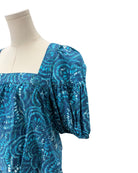 Blue patterned dress on a mannequin against a white background