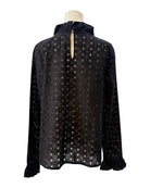 Black blouse with a eyelet pattern on a mannequin against a white background