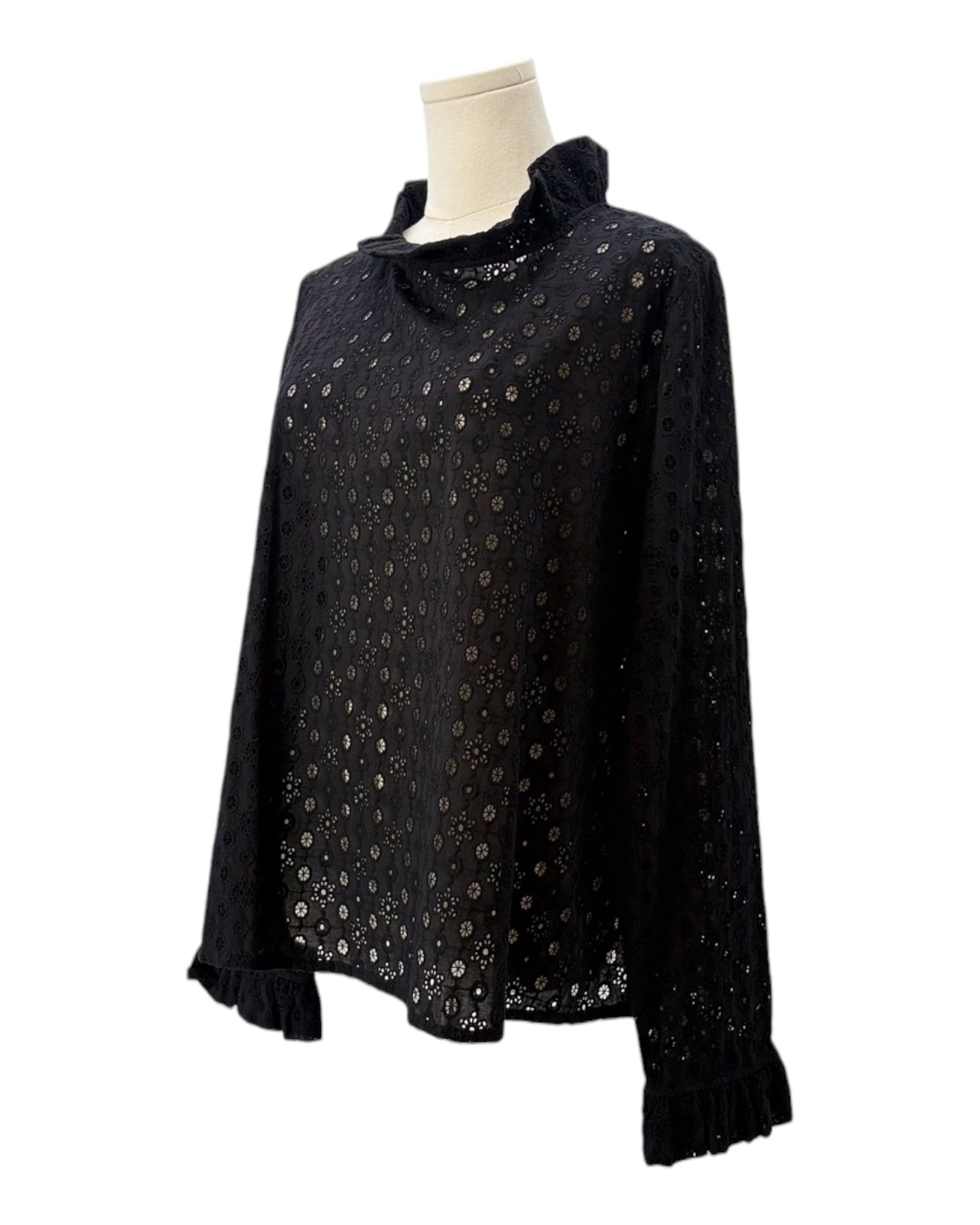 Black blouse with eyelet fabric on a mannequin against a white background