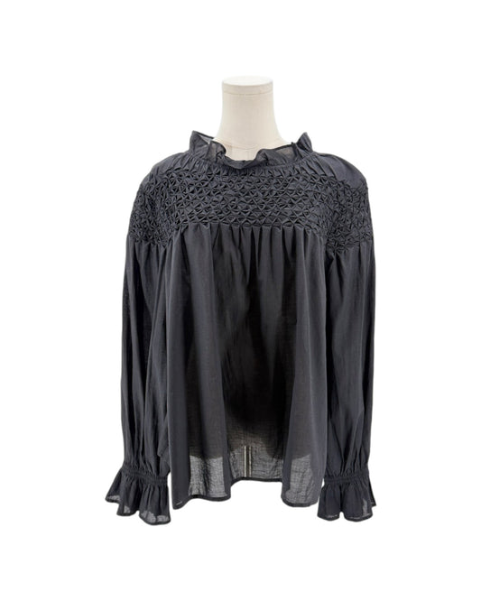 Black blouse with lace detailing on a mannequin against a white background