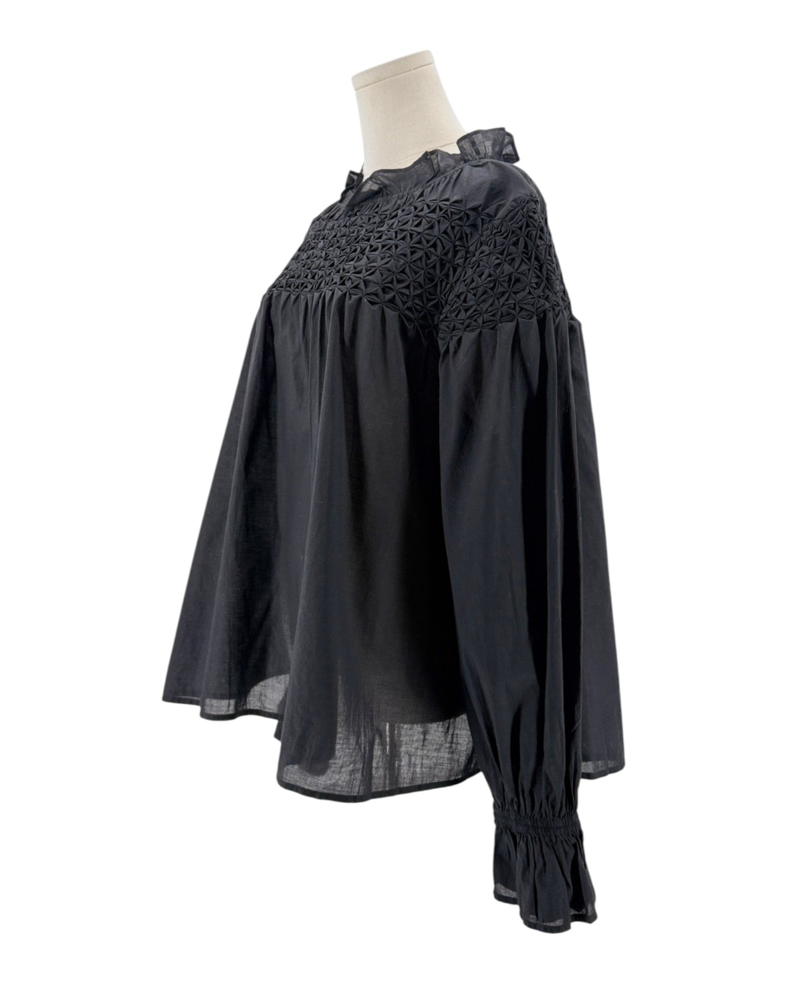 Black dress with lace detailing on a mannequin against a white background