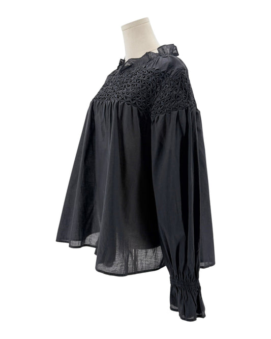 Black dress with lace detailing on a mannequin against a white background