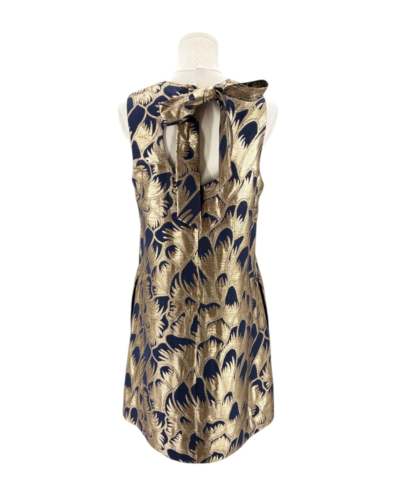 Gold and navy patterned dress on a mannequin against a white background