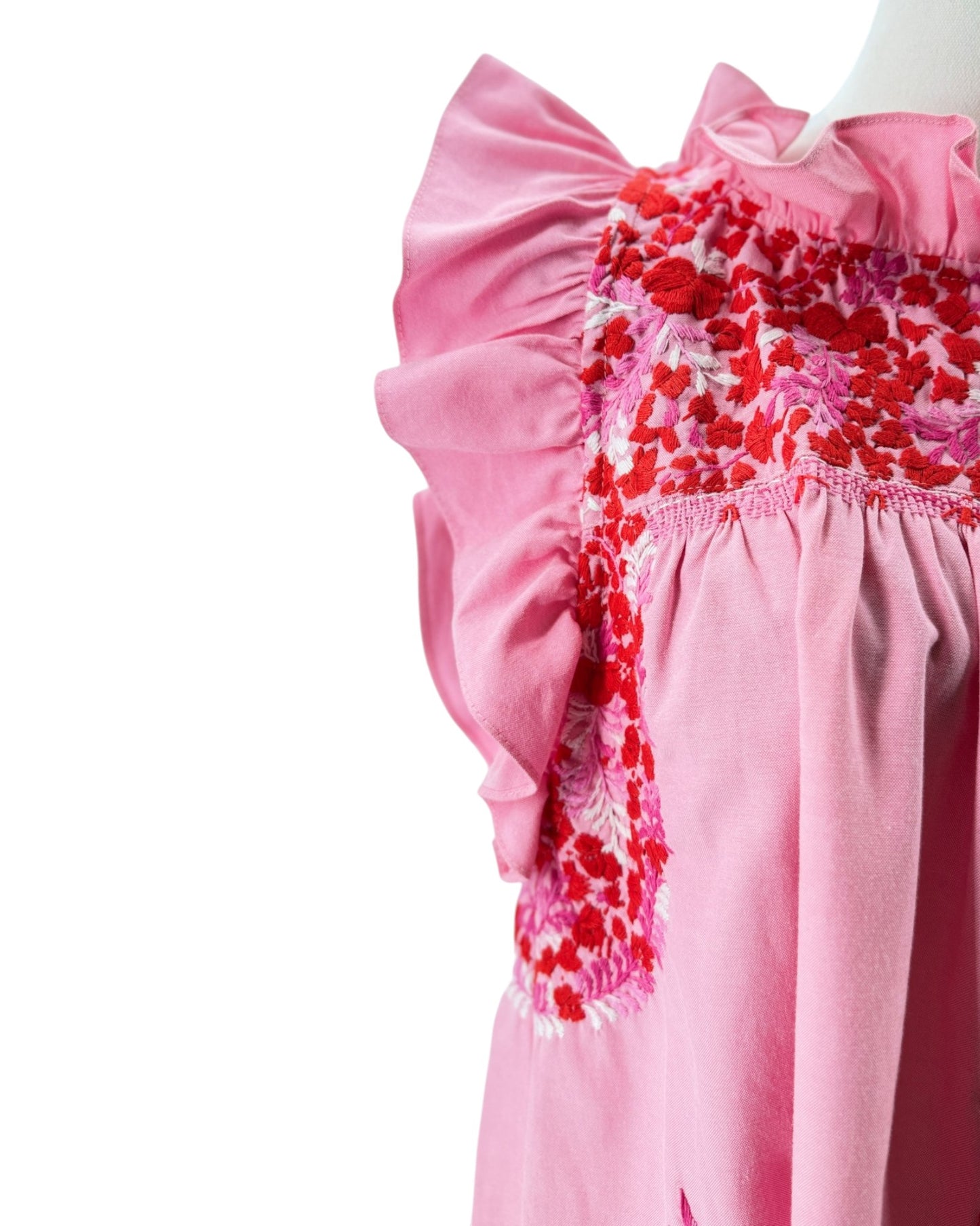 Pink dress with floral embroidery on a white background