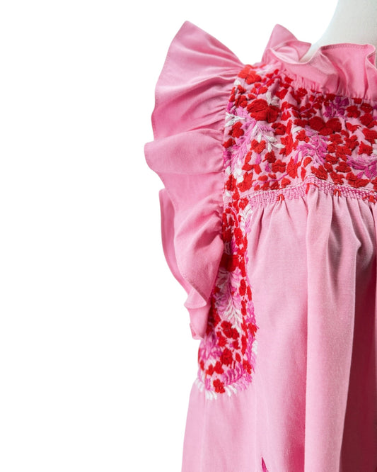 Pink dress with floral embroidery on a white background