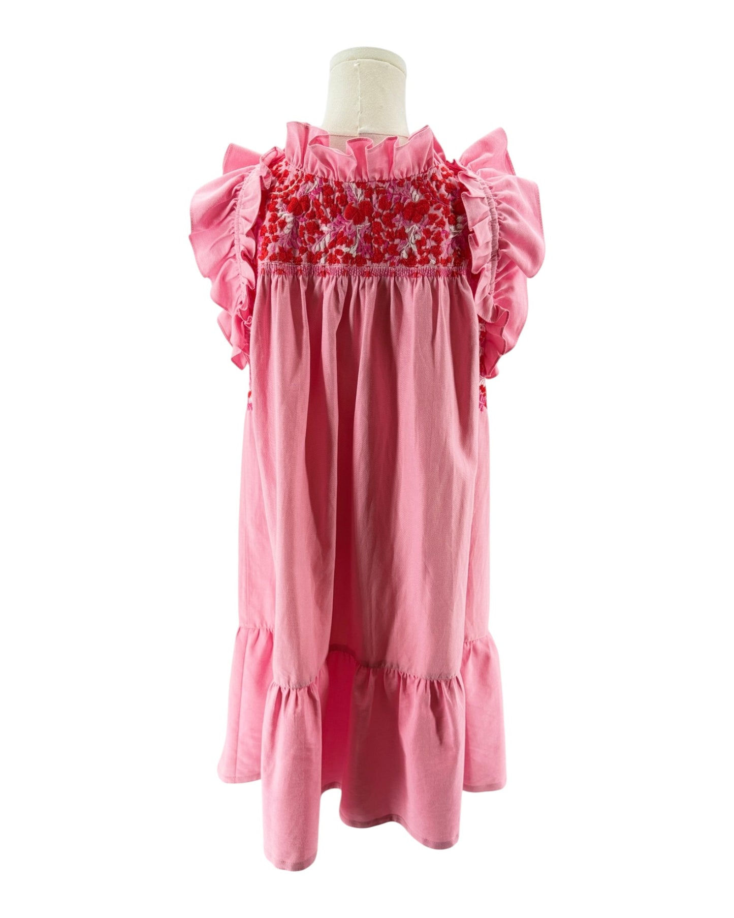 Pink dress with floral smocking on a mannequin against a white background