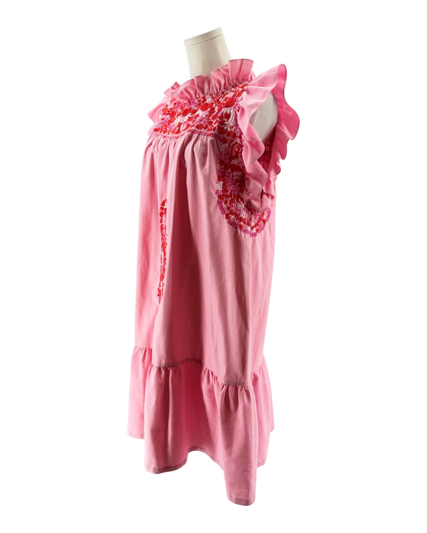 Pink dress with floral details on a mannequin against a white background