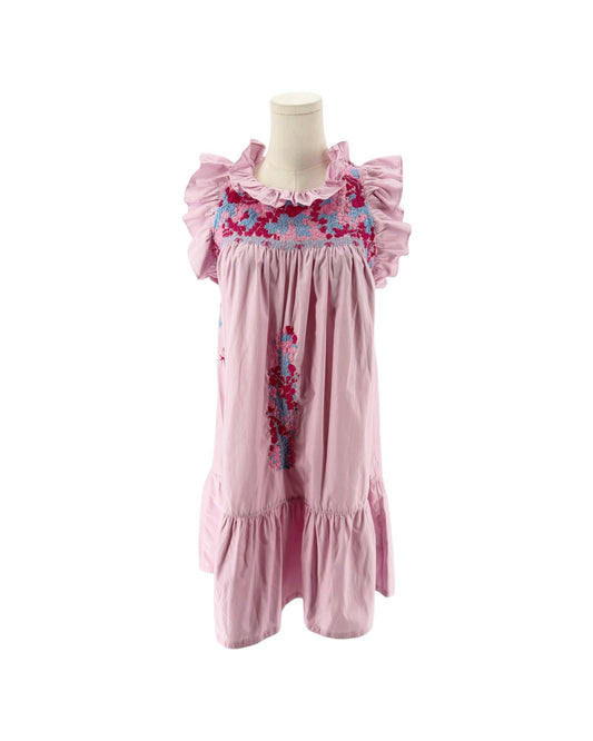A pink cotton mini dress with ruffled sleeves and a smocked floral chest panel, displayed on a mannequin torso against a white background.