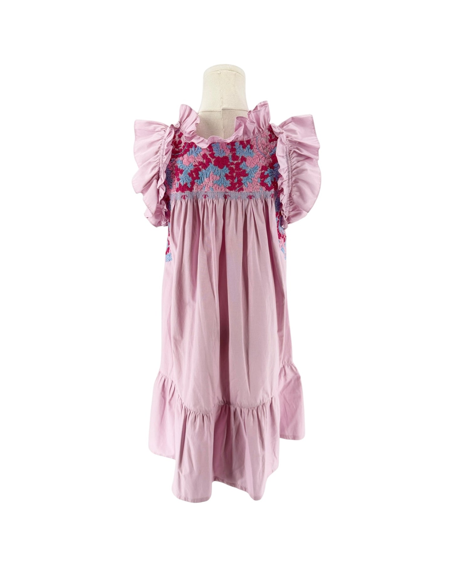 A pink smocked mini dress with ruffled sleeves and a colorful floral smocked bodice, displayed on a mannequin against a white background. 