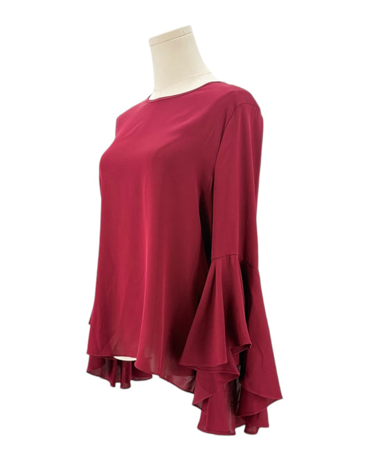 Red blouse with ruffled sleeves on a mannequin against a white background