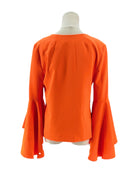 Orange blouse with bell sleeves on a mannequin against a white background