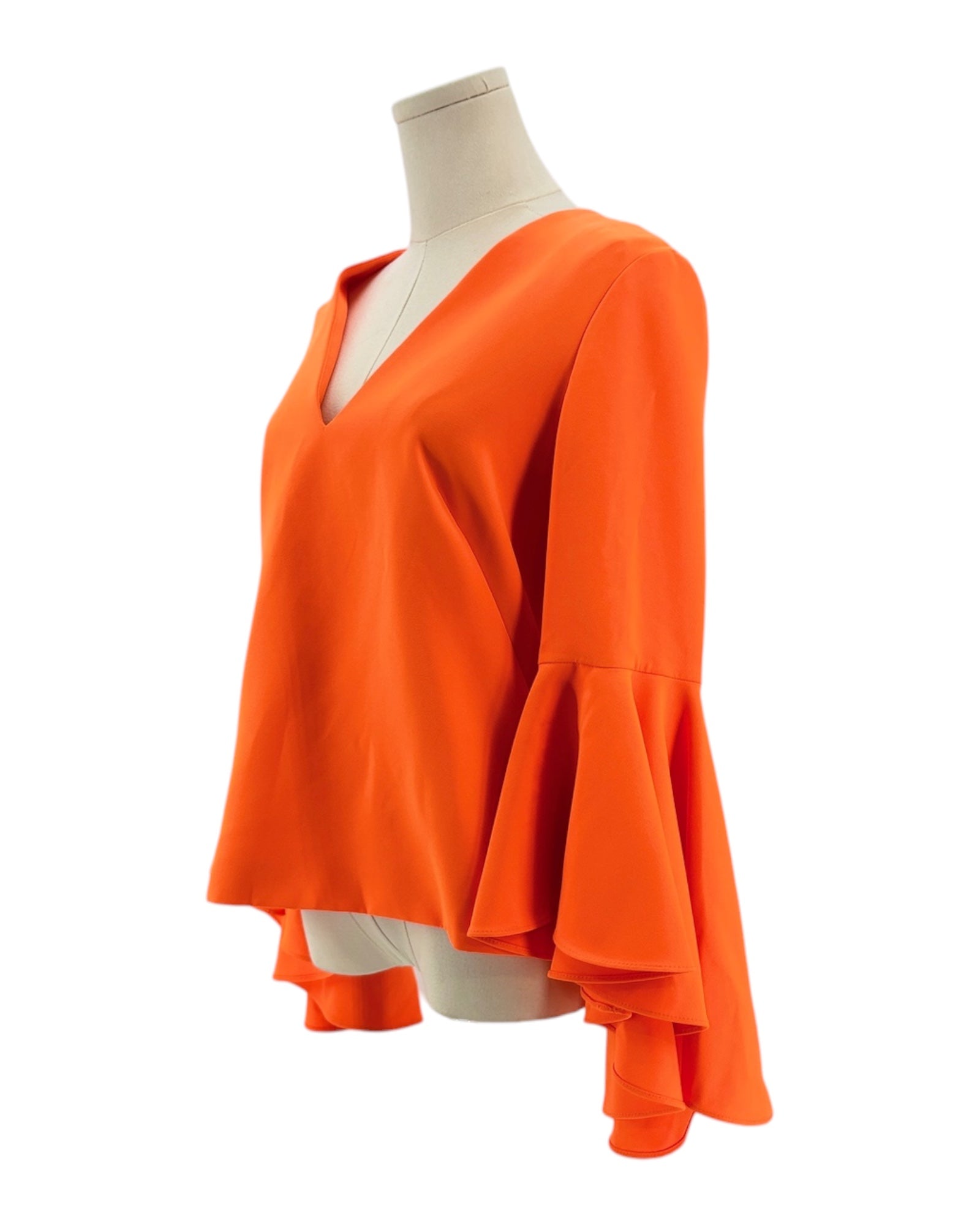 Orange blouse with ruffled sleeves on a mannequin against a white background