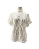 White lace blouse on a mannequin against a white background
