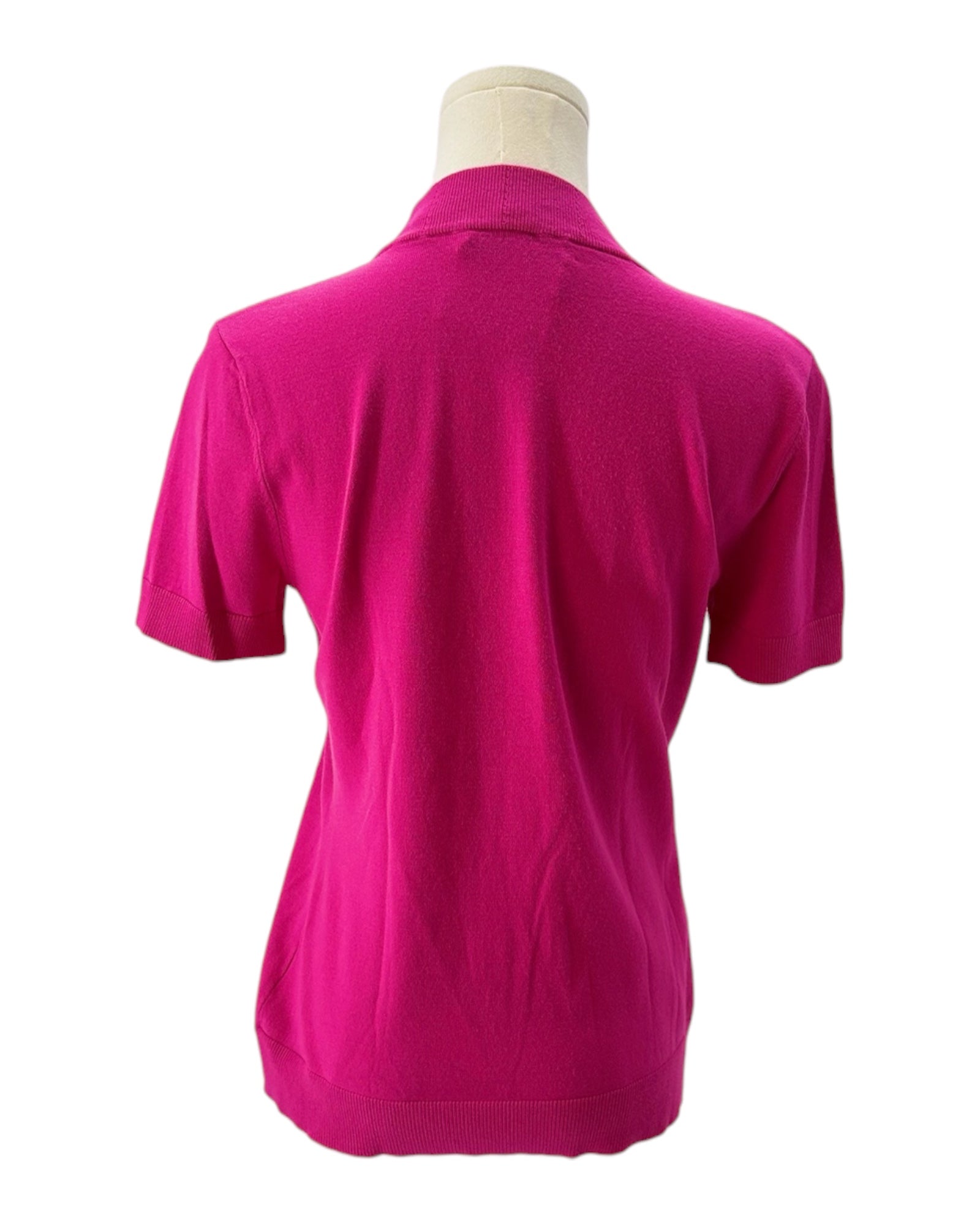 Pink knit shirt on a mannequin against a white background