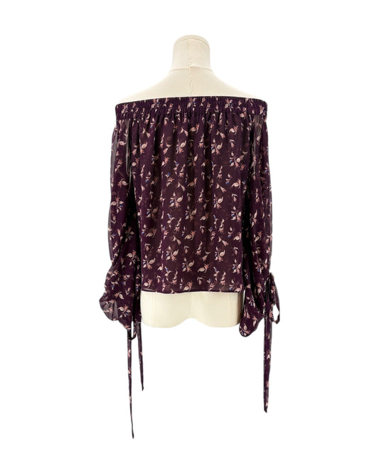 Purple floral off-shoulder blouse on a mannequin against a white background