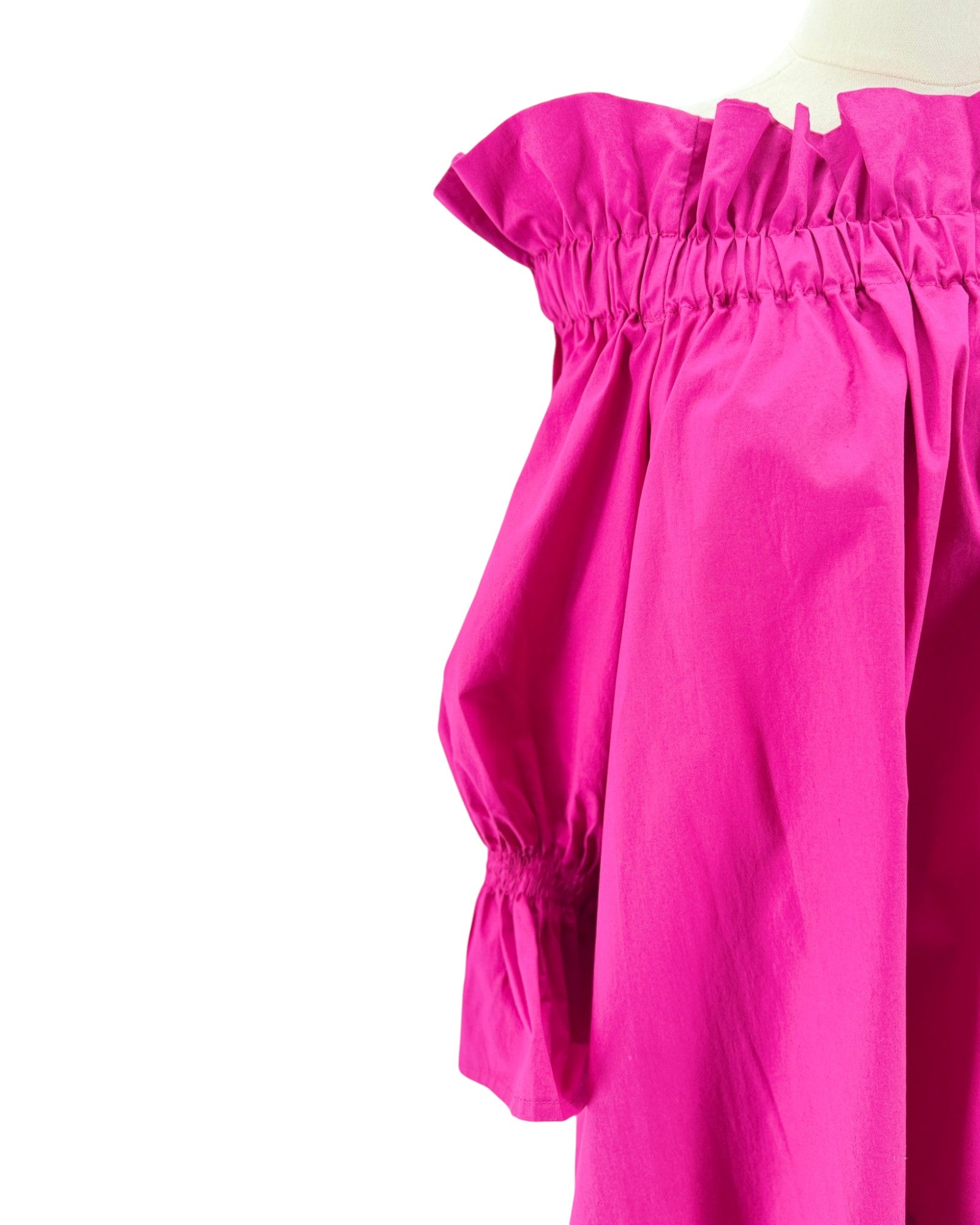 Close-up of a bright pink off-shoulder top on a white background