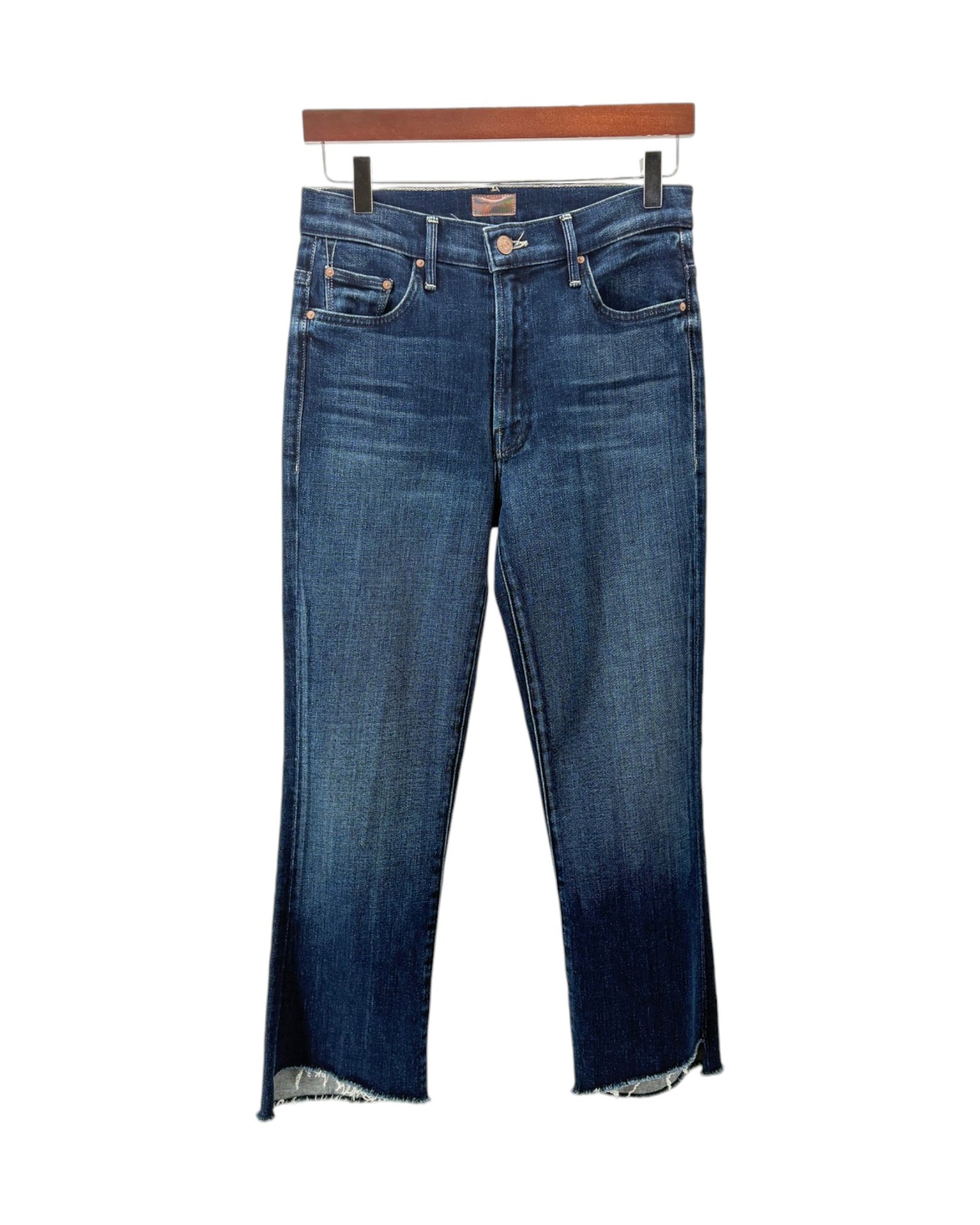 A pair of medium wash blue denim jeans with a faded dark wash on the legs, hanging from a wooden hanger against a plain white background.