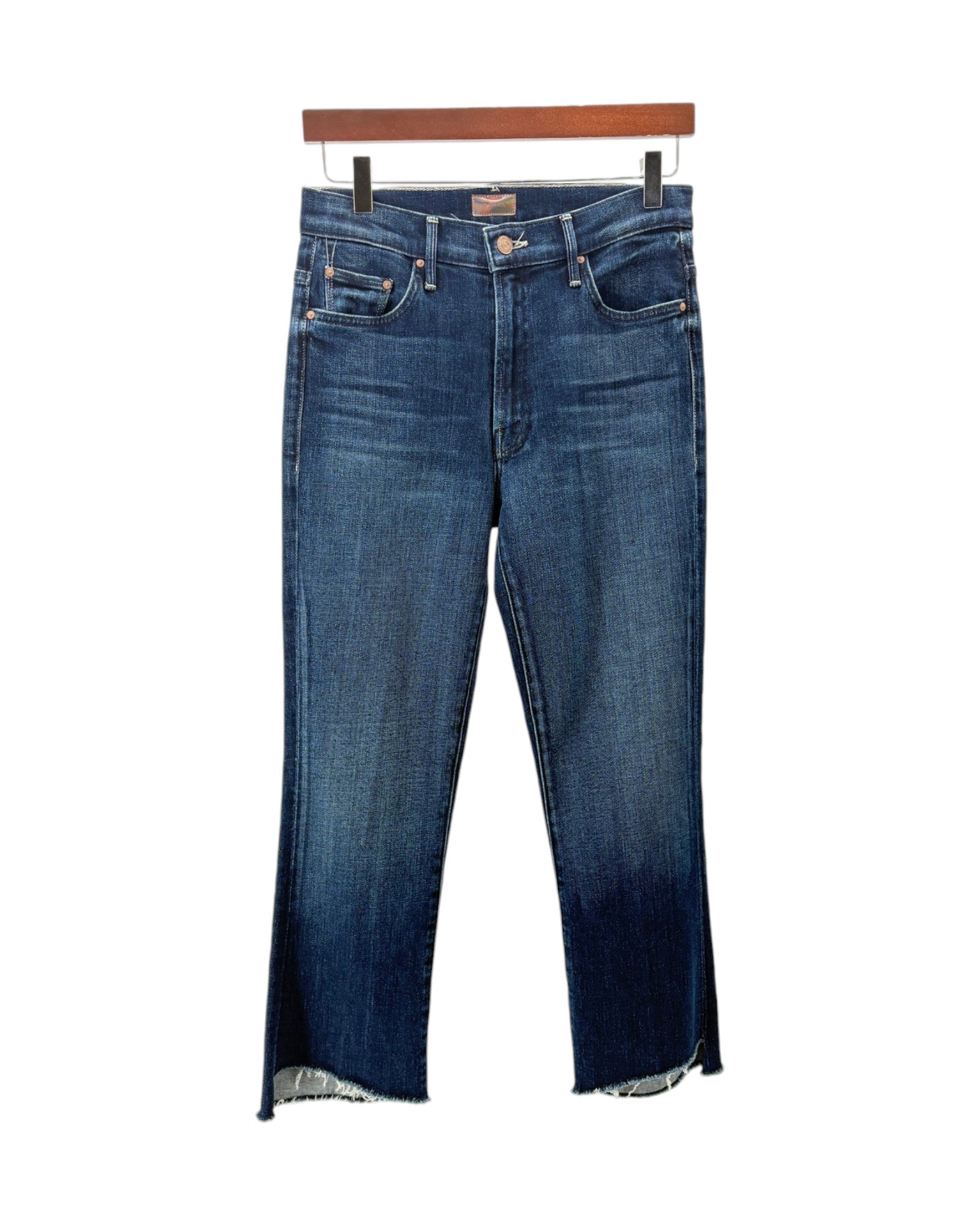 A pair of medium wash blue denim jeans with a faded dark wash on the legs, hanging from a wooden hanger against a plain white background.